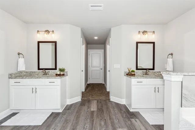 a en suite bathroom with a granite countertop sink and a mirror