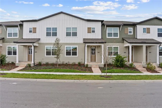 an aerial view of residential houses with outdoor space and lake view