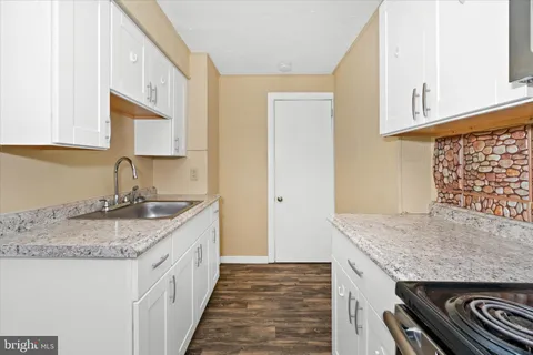 a kitchen with granite countertop a sink and a stove