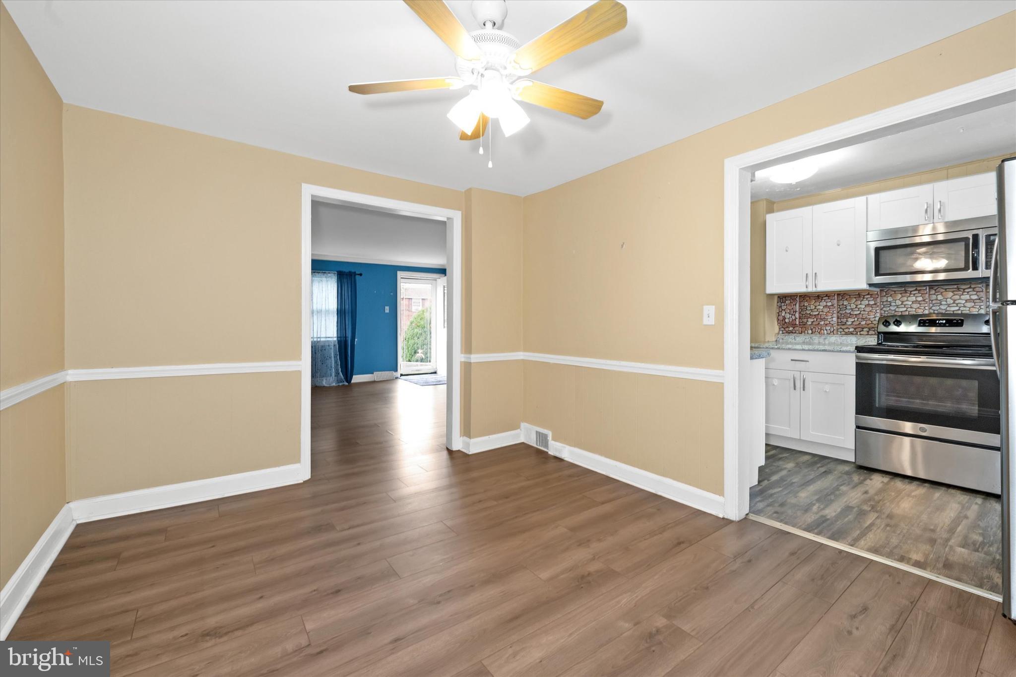1950 Prospect Road Wilmington, DE 19805 - Photo 7 of 27 an empty room with wooden floor a ceiling fan and windows