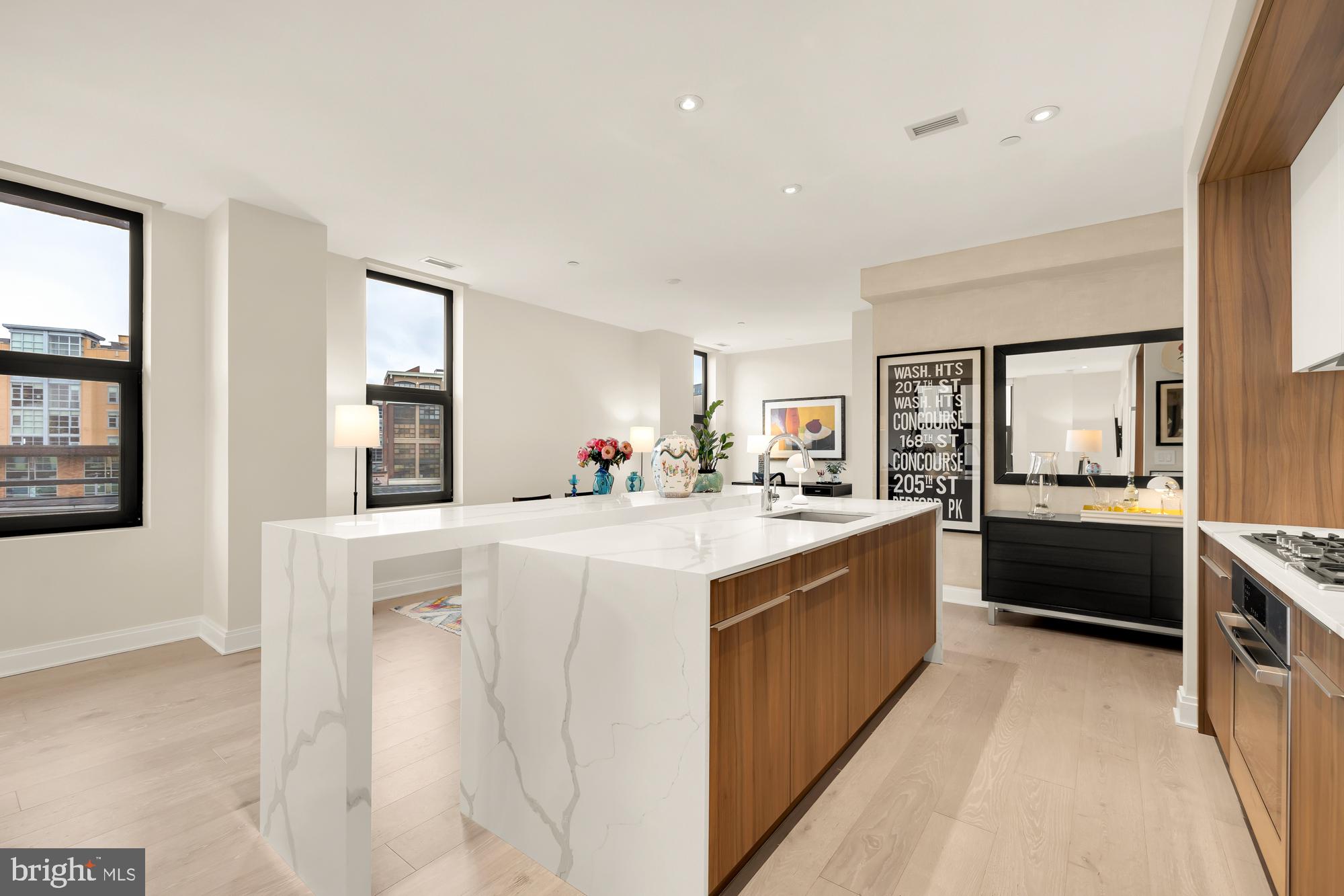 1427 Rhode Island Avenue Northwest, Unit 404 Washington, DC 20005 - Photo 14 of 35 a large kitchen with kitchen island white cabinets and stainless steel appliances