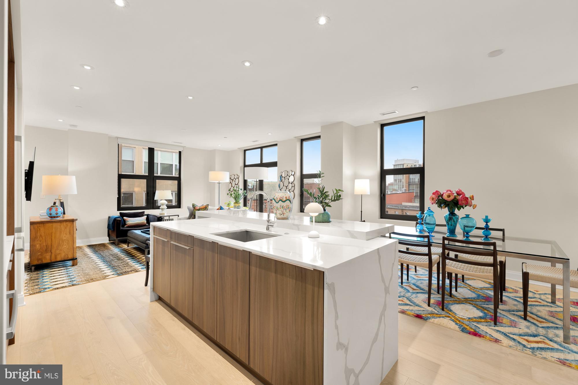 1427 Rhode Island Avenue Northwest, Unit 404 Washington, DC 20005 - Photo 9 of 35 a living room with stainless steel appliances kitchen island a table and chairs in it
