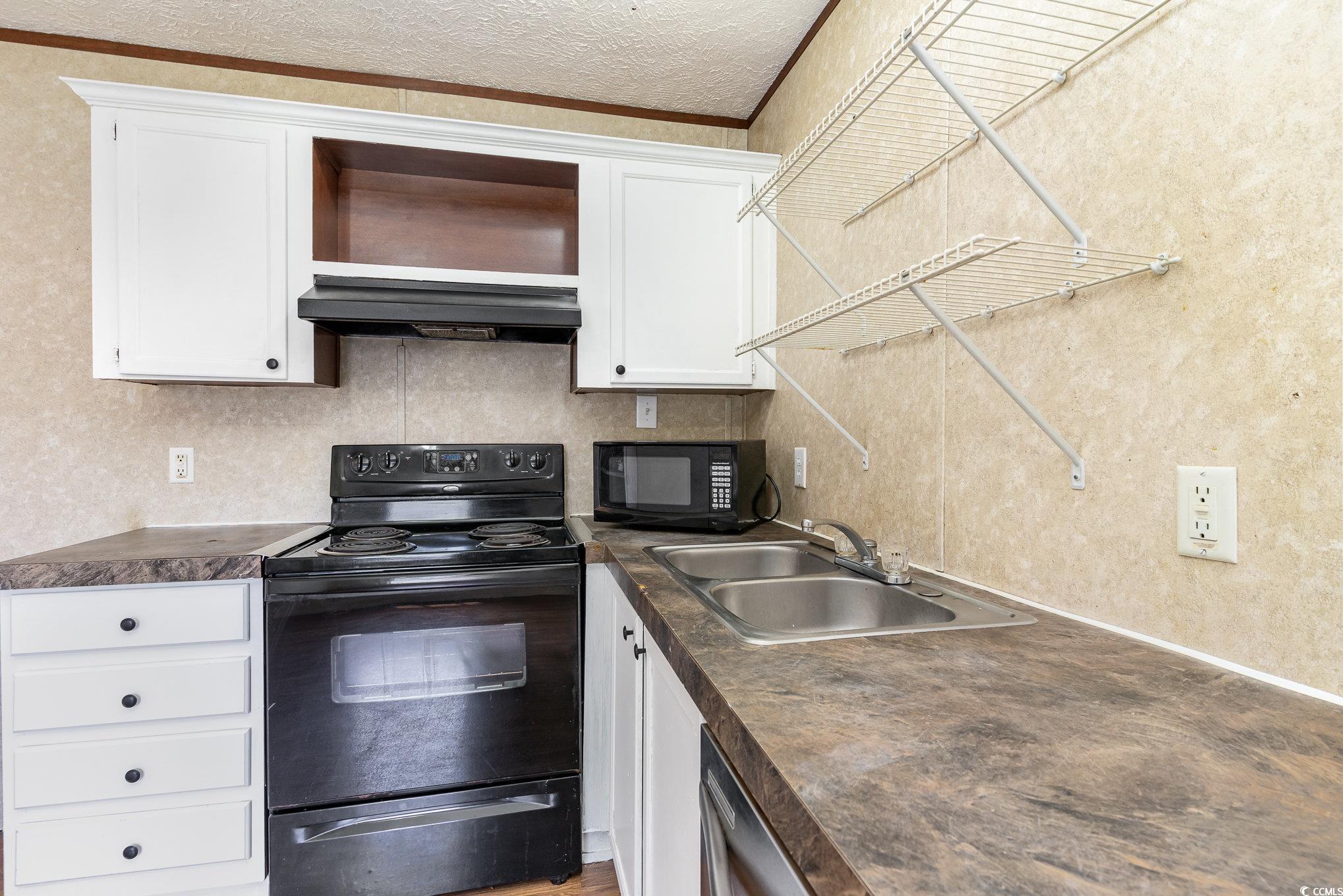 2100 Highway 15 Myrtle Beach, SC 29577 - Photo 11 of 35 Kitchen with white cabinets, black appliances, sink, a textured ceiling, and custom range hood