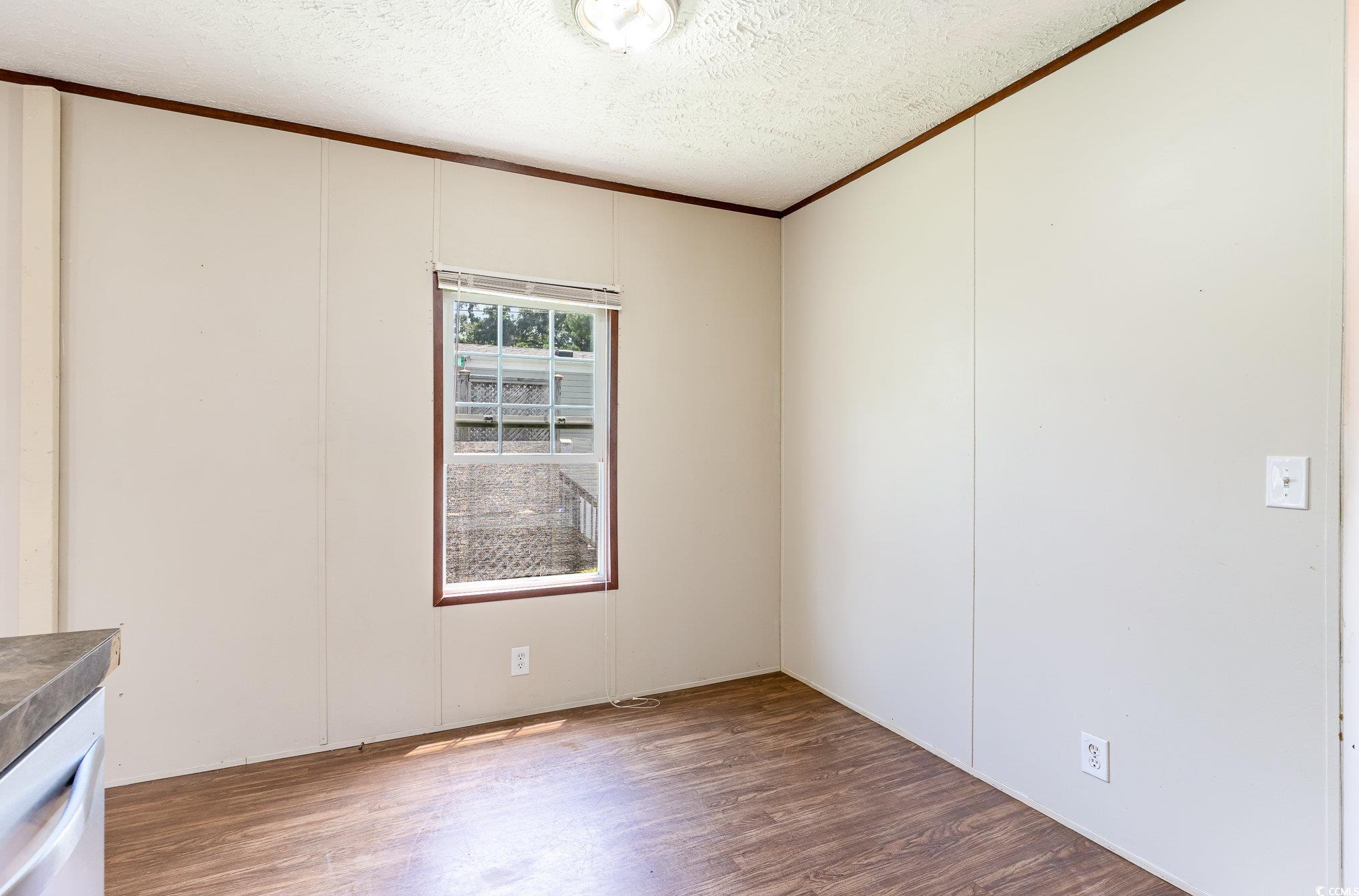 2100 Highway 15 Myrtle Beach, SC 29577 - Photo 12 of 35 Empty room with a textured ceiling, wood-type flooring, and ornamental molding