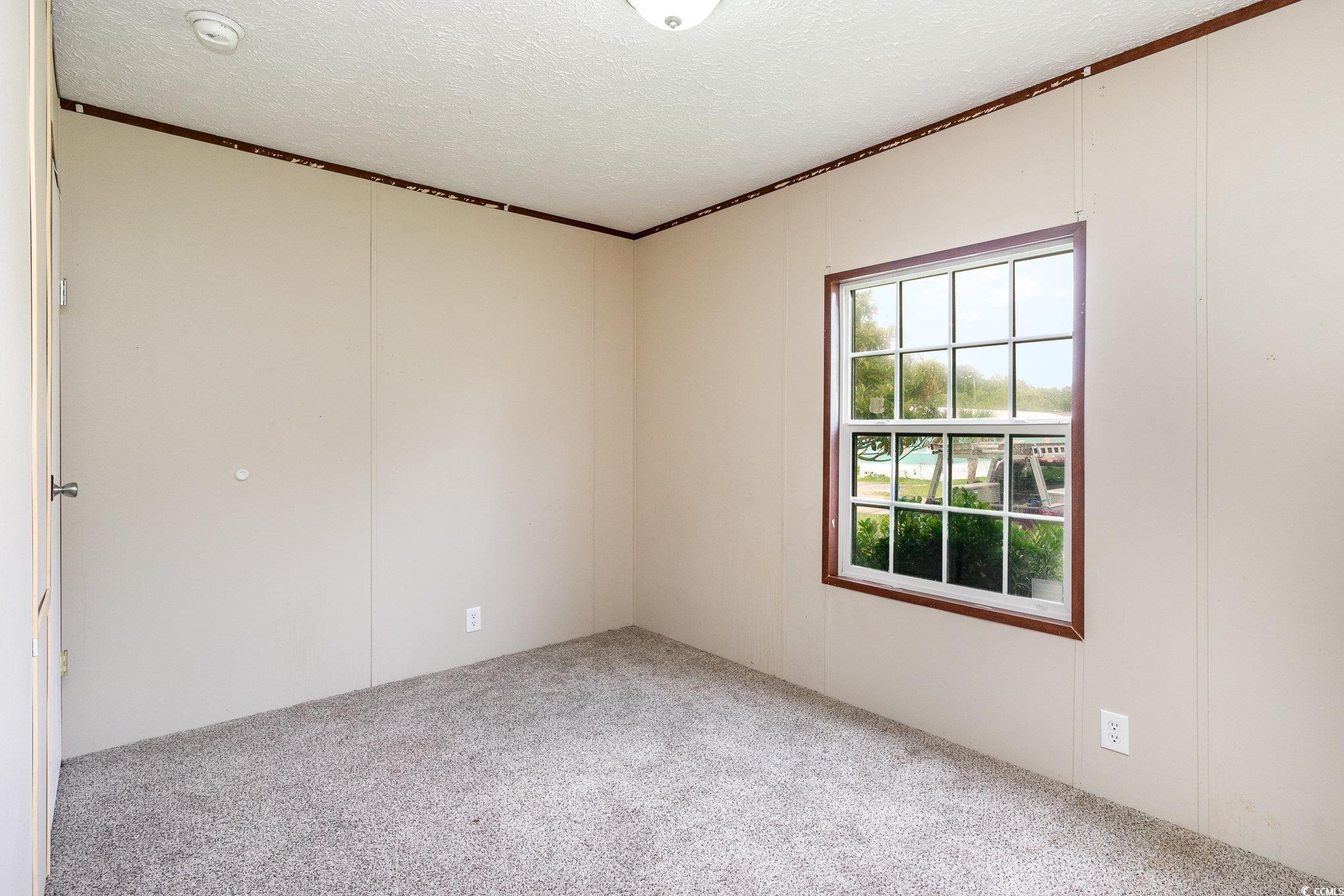 2100 Highway 15 Myrtle Beach, SC 29577 - Photo 15 of 35 Carpeted spare room featuring crown molding and a textured ceiling