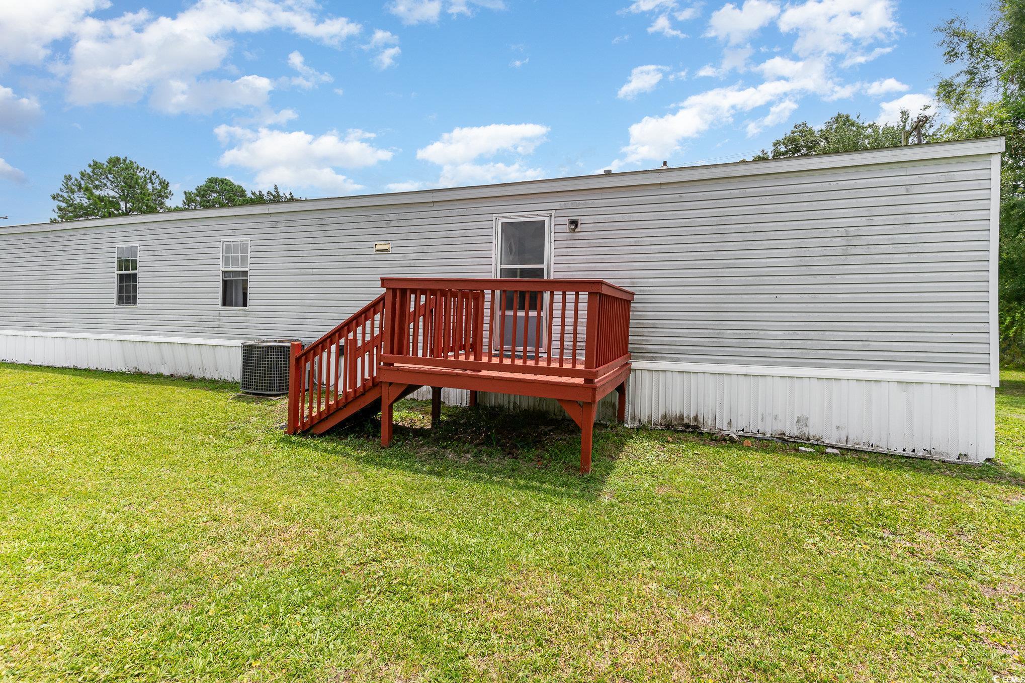 2100 Highway 15 Myrtle Beach, SC 29577 - Photo 29 of 35 Rear view of property featuring a deck, central AC, and a lawn
