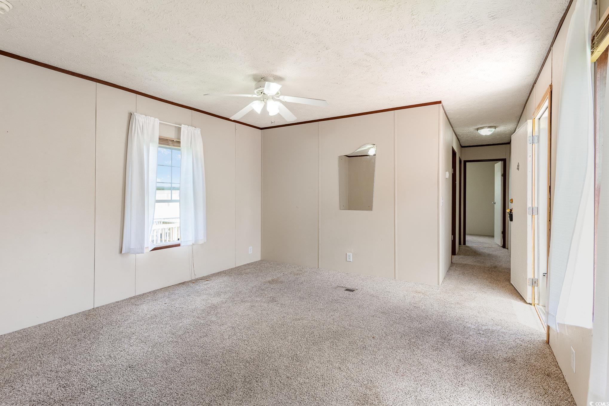 2100 Highway 15 Myrtle Beach, SC 29577 - Photo 5 of 35 Unfurnished room with light colored carpet, a textured ceiling, ceiling fan, and crown molding