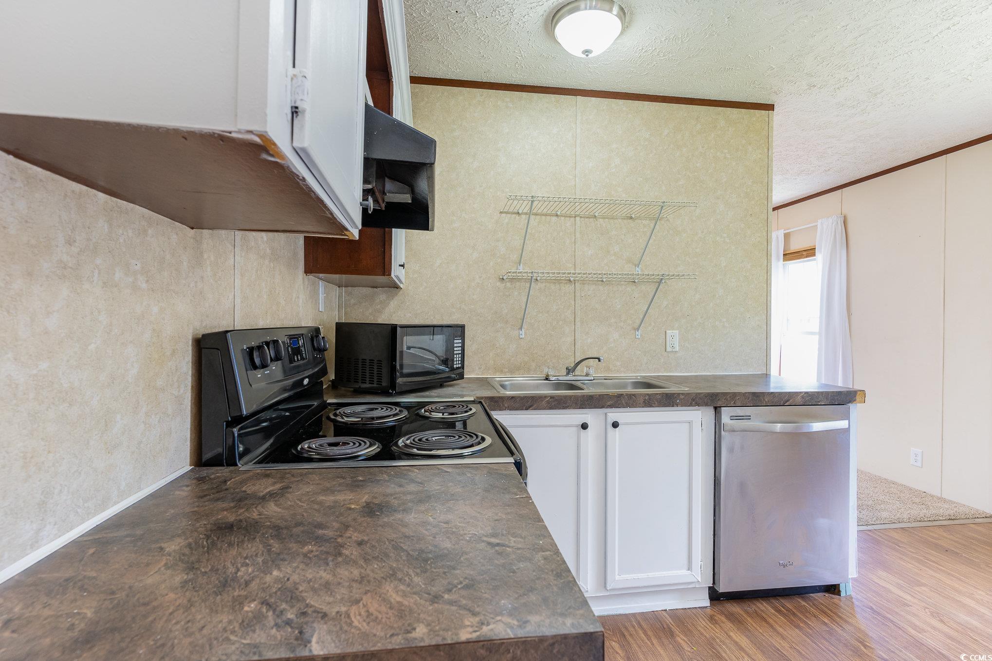 2100 Highway 15 Myrtle Beach, SC 29577 - Photo 10 of 35 Kitchen featuring stainless steel dishwasher, white cabinetry, light wood-type flooring, sink, and electric range oven