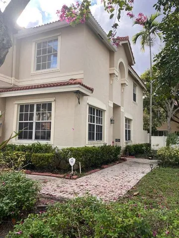a front view of a house with garden and yard