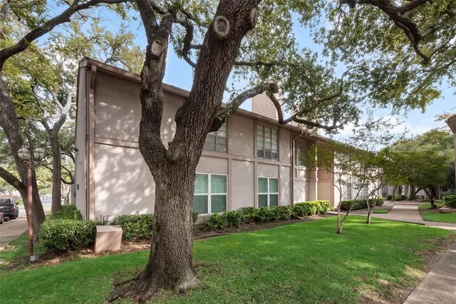 a tree in front of a white house