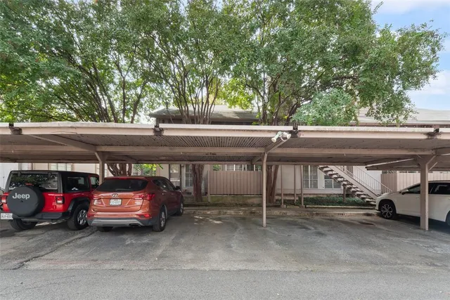 a view of a house with a large space and a car park in front of it