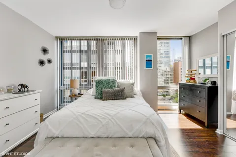 a bedroom with a bed and wooden floor