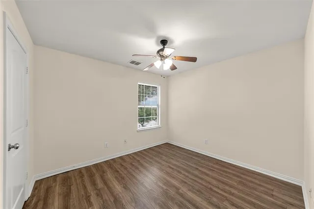a view of a room with wooden floor and a ceiling fan