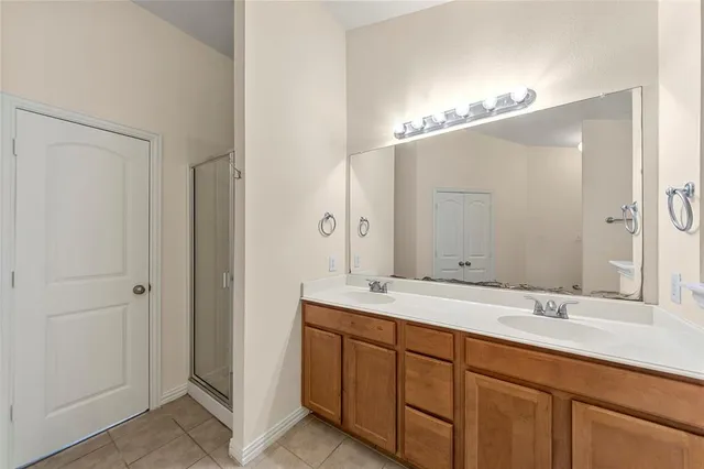 a bathroom with a tub a double vanity sink and a mirror