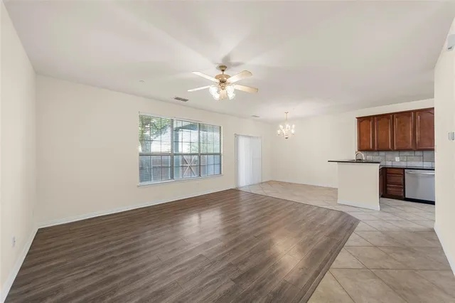 a view of an empty room with a kitchen and a window
