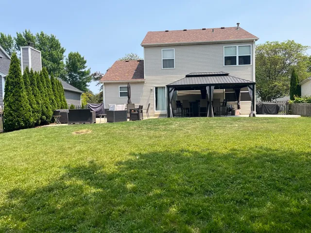 a view of a house with a yard and sitting area