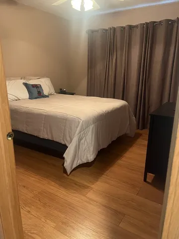 a bedroom with a bed and wooden floor