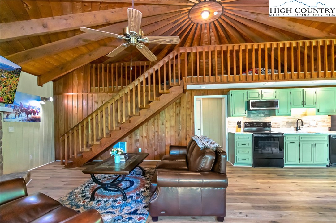 104 Hornbeam Road Beech Mountain, NC 28604 - Photo 11 of 40 a living room with couches and a dining table with wooden floor