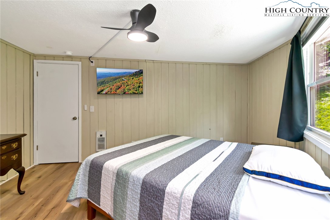 104 Hornbeam Road Beech Mountain, NC 28604 - Photo 18 of 40 a bedroom with a bed and a chandelier