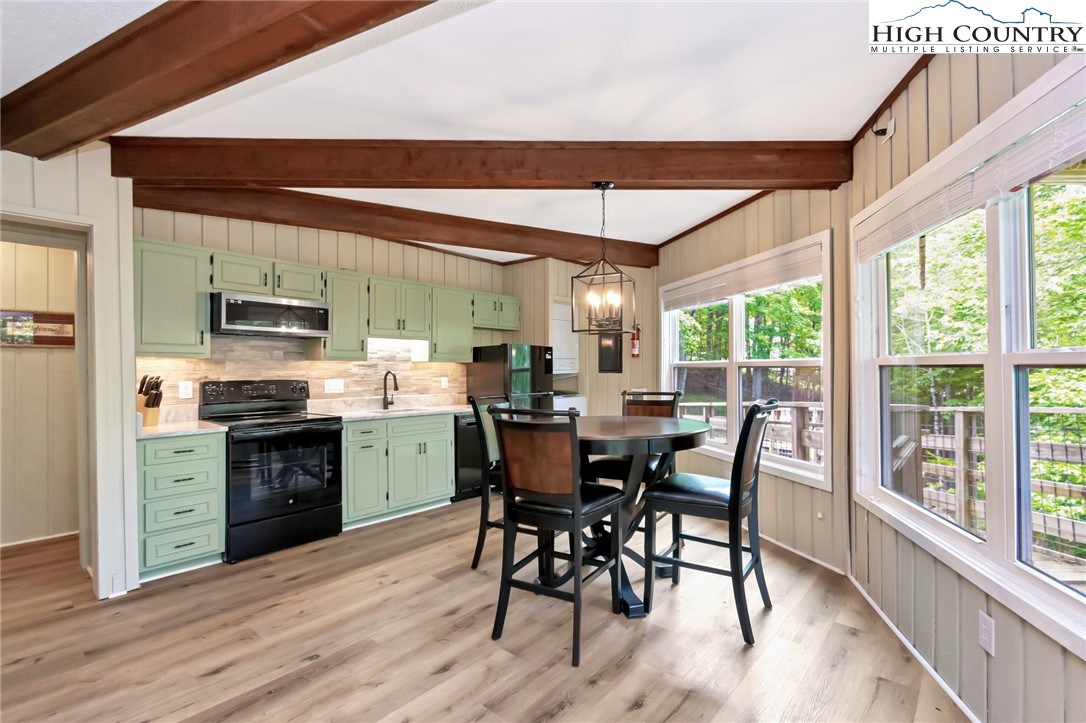 104 Hornbeam Road Beech Mountain, NC 28604 - Photo 28 of 40 a kitchen with a table chairs microwave and stove top oven