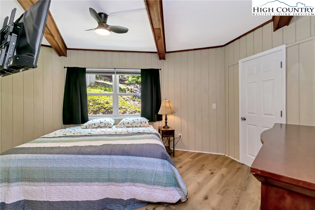 104 Hornbeam Road Beech Mountain, NC 28604 - Photo 33 of 40 a bedroom with a bed and a chandelier