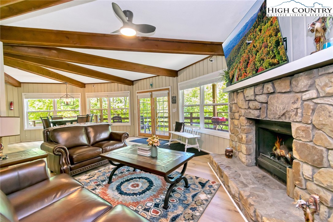 104 Hornbeam Road Beech Mountain, NC 28604 - Photo 36 of 40 a living room with furniture a fireplace and a floor to ceiling window