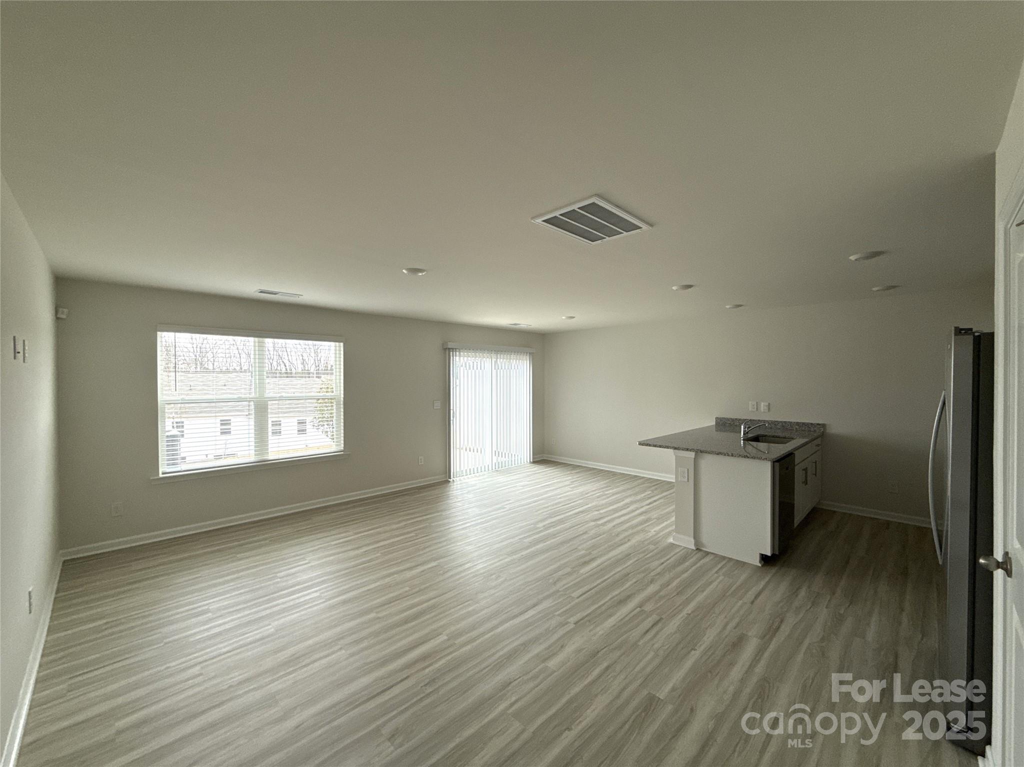 4148 Lurelin Road Charlotte, NC 28262 - Photo 2 of 12 wooden floor in an empty room with a window