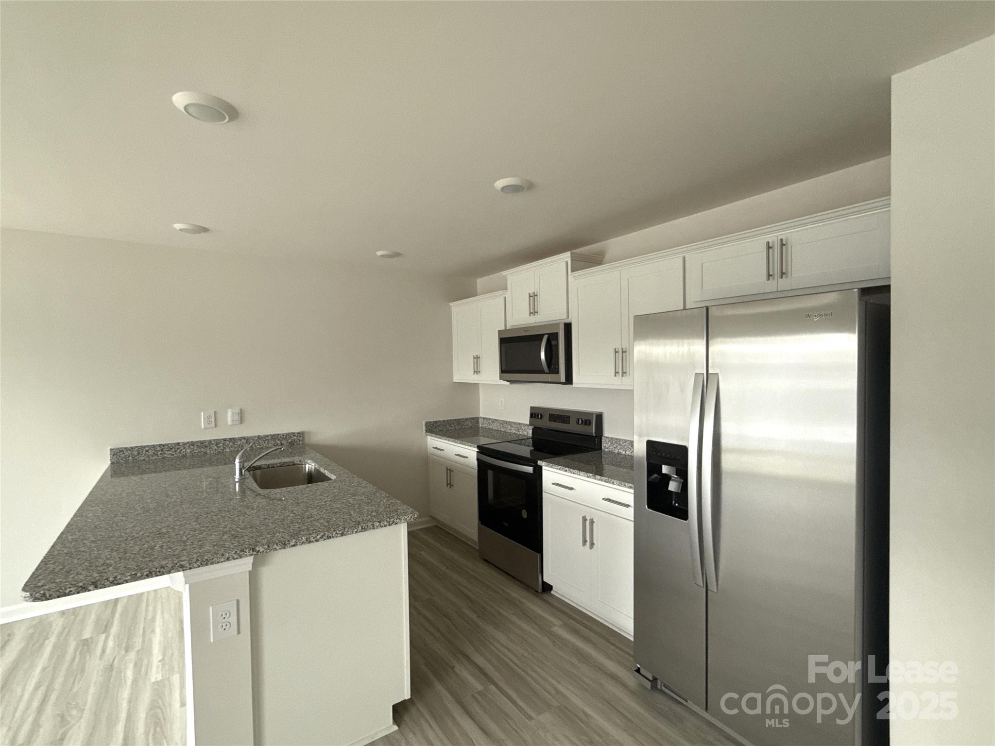 4148 Lurelin Road Charlotte, NC 28262 - Photo 3 of 12 a kitchen with stainless steel appliances granite countertop a refrigerator a stove top oven a sink and dishwasher