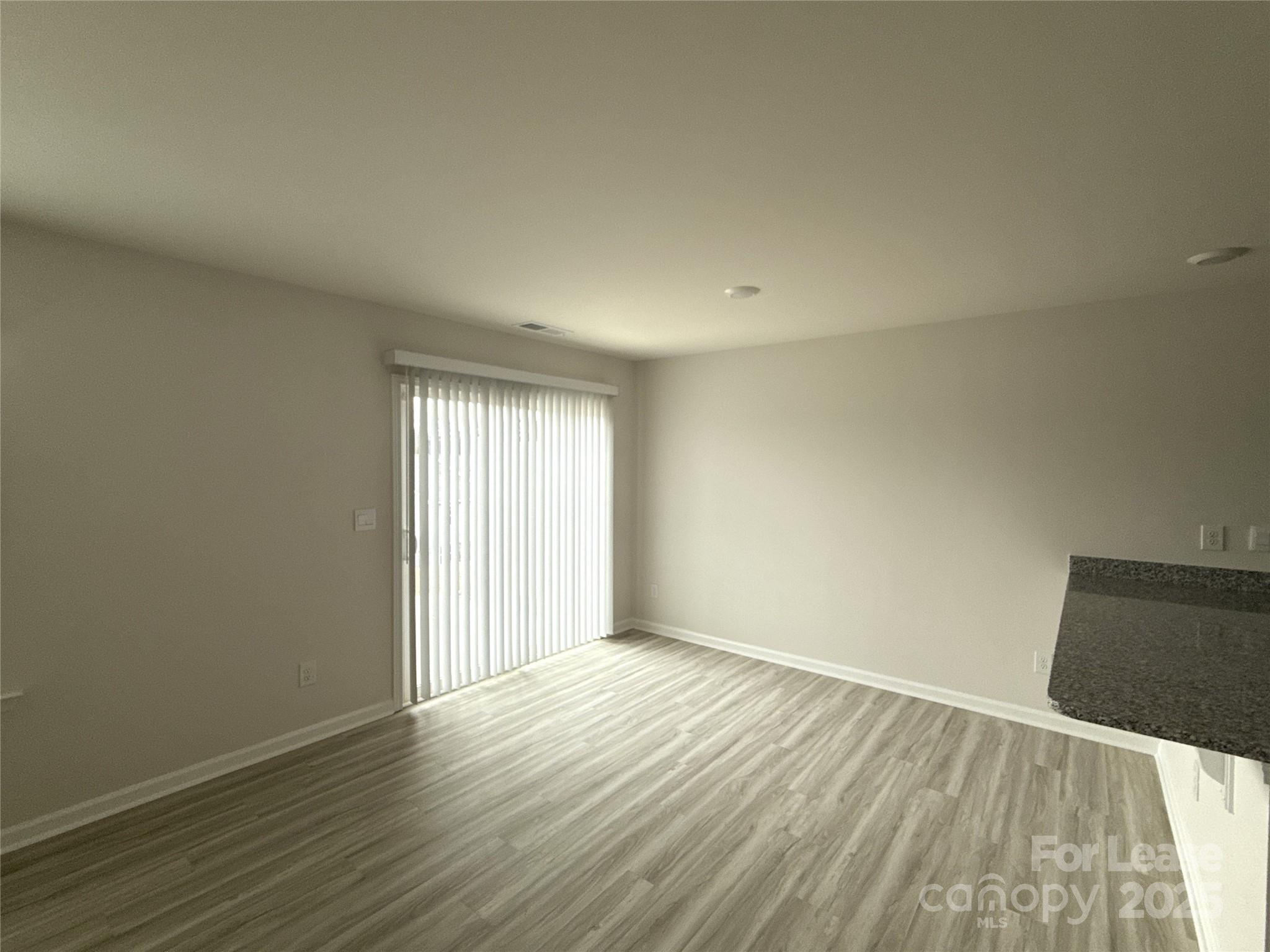 4148 Lurelin Road Charlotte, NC 28262 - Photo 5 of 12 an empty room with wooden floor and windows