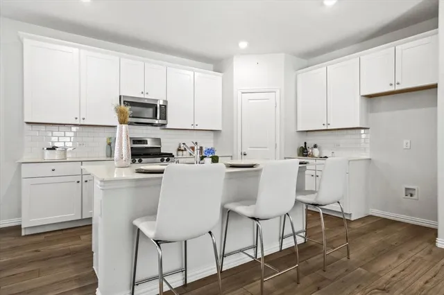 a kitchen with white cabinets and stainless steel appliances