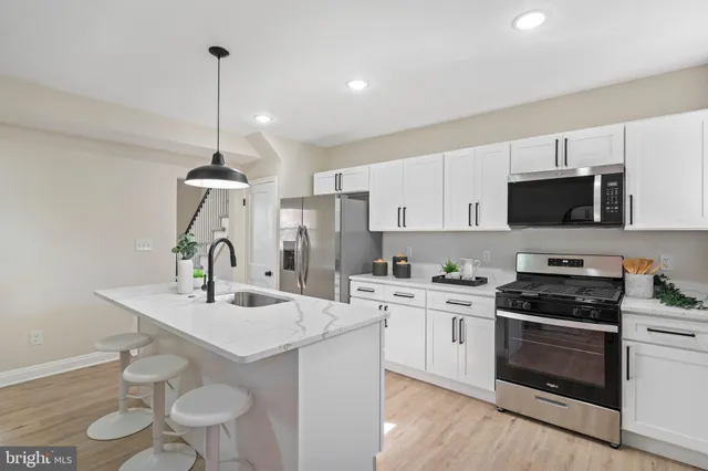 a kitchen with a sink a stove a microwave and cabinets