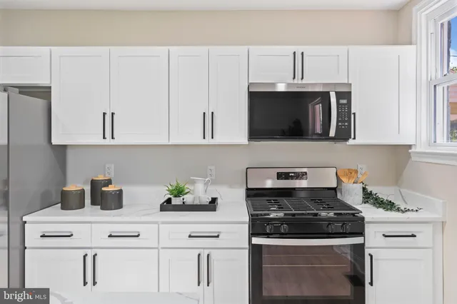 a kitchen with white cabinets and appliances