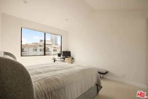 a bedroom with a bed and a large window