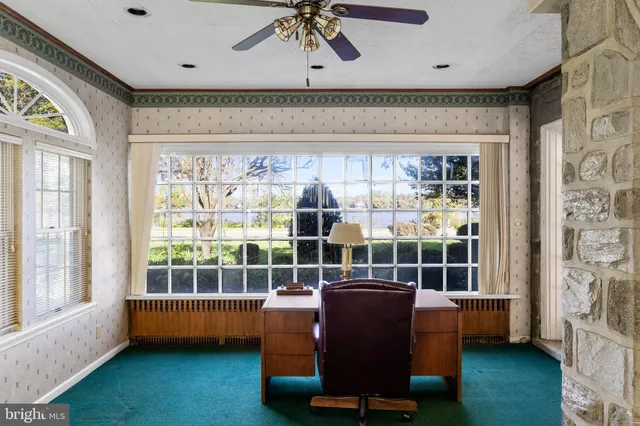 a view of a livingroom with wooden floor and a ceiling fan