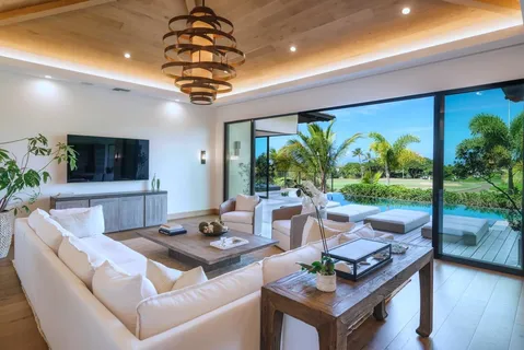 a living room with patio furniture and a flat screen tv
