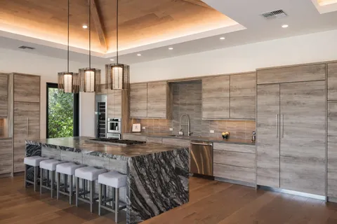 a kitchen with stainless steel appliances kitchen island granite countertop a stove a sink and cabinets