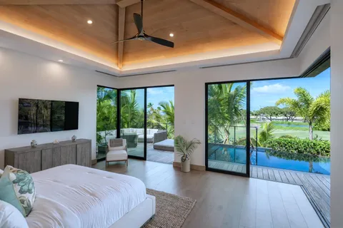 a spacious bedroom with a large bed and a flat tv screen