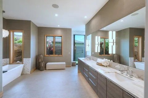 a bathroom with a granite countertop tub sink and mirror