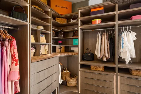 a view of walk in closet with clothes and shoes