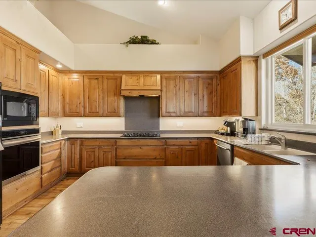 a kitchen with stainless steel appliances granite countertop a sink stove and microwave