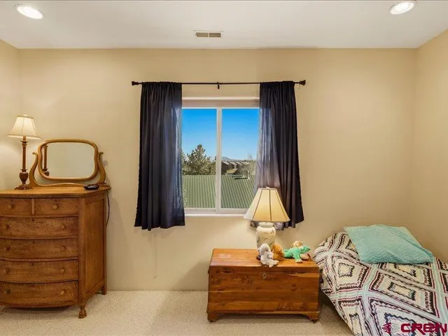a living room with couches a flat screen tv and kitchen view