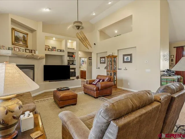 a living room with furniture kitchen view and a flat screen tv