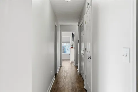 a view of a hallway with wooden floor