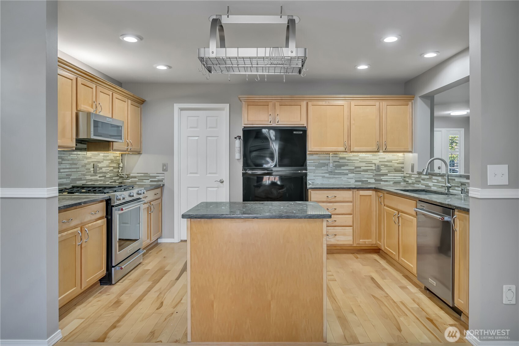 23516 Southeast 243rd Place Maple Valley, WA 98038 - Photo 13 of 33 a kitchen with stainless steel appliances a stove sink microwave and cabinets