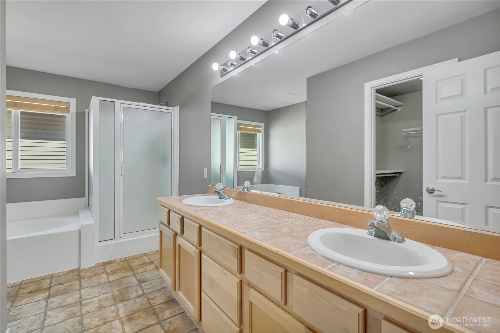 23516 Southeast 243rd Place Maple Valley, WA 98038 - Photo 21 of 31 a bathroom with a sink double vanity granite tub shower and a mirror