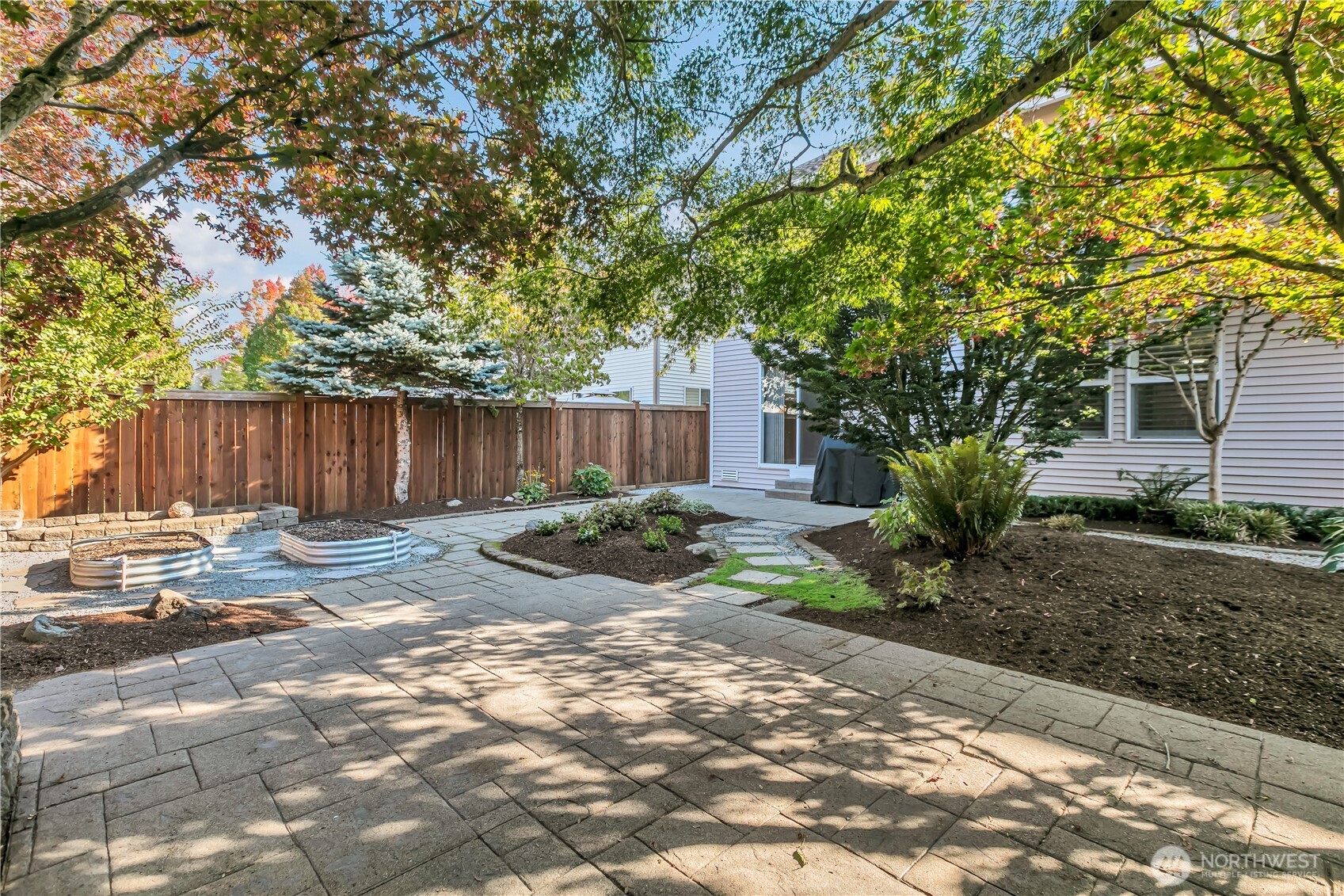23516 Southeast 243rd Place Maple Valley, WA 98038 - Photo 28 of 31 a view of a backyard with large trees and wooden fence