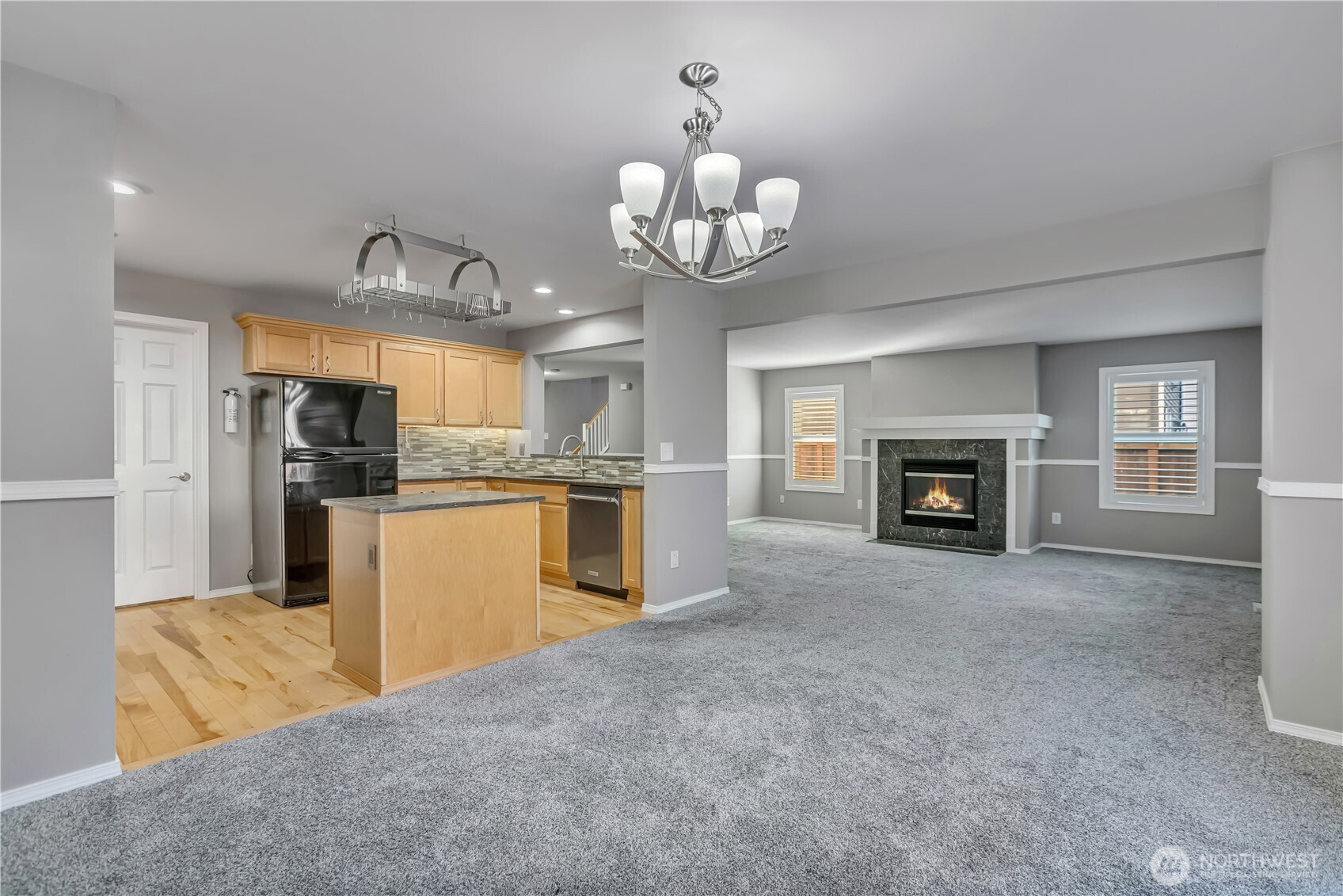 23516 Southeast 243rd Place Maple Valley, WA 98038 - Photo 8 of 31 a kitchen with kitchen island granite countertop wooden floor stainless steel appliances and a chandelier