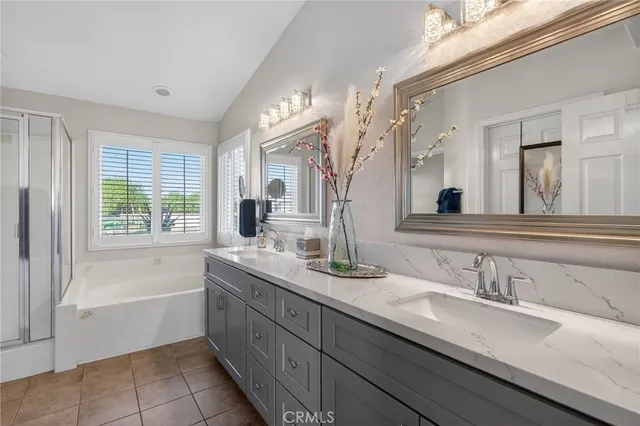 a bathroom with a granite countertop sink mirror and a bathtub