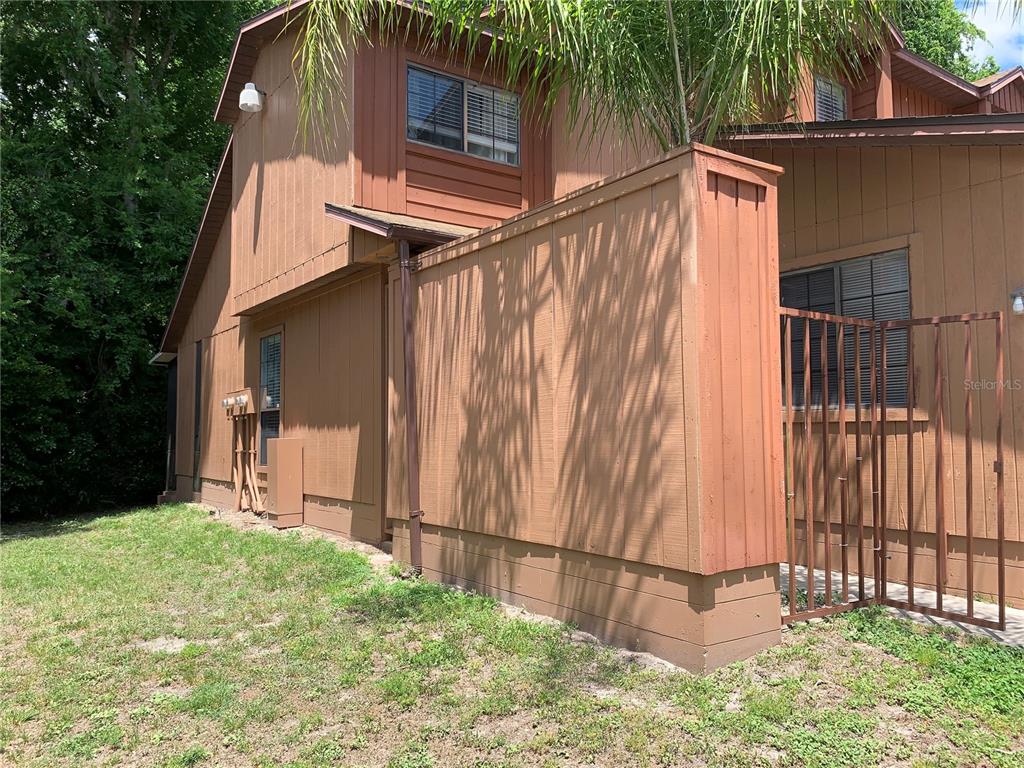 5754 Southwest 8th Place Gainesville, FL 32607 - Photo 27 of 29 a backyard of a house with large trees and wooden fence