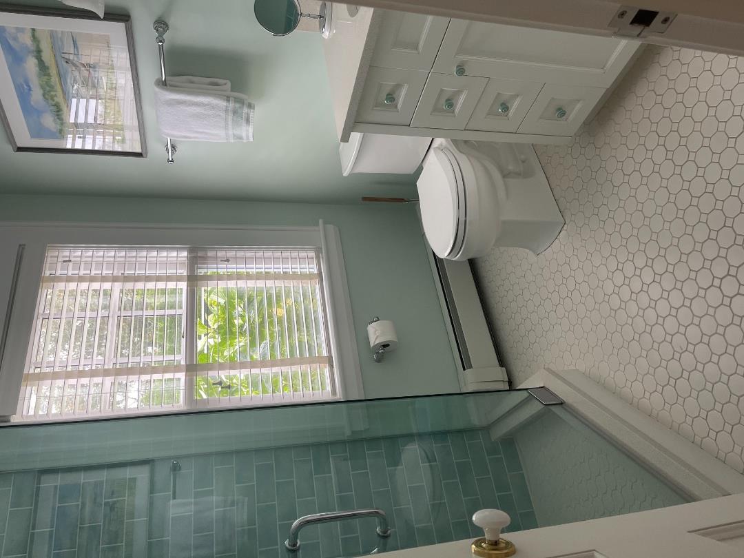 43 Cottage Street Edgartown, MA 02539 - Photo 14 of 24 a bathroom with a granite countertop toilet a sink and a shower